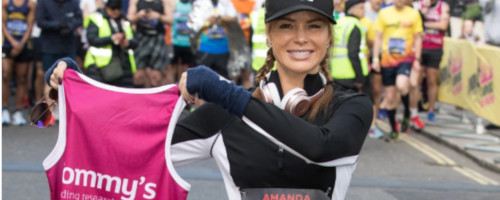 Amanda Holden holding a Tommy's running vest